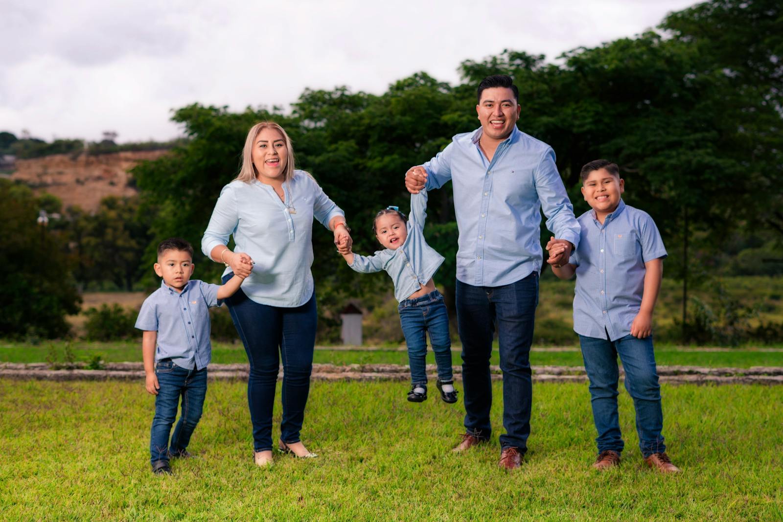 Family of five in matching outfits enjoying a sunny day outdoors.